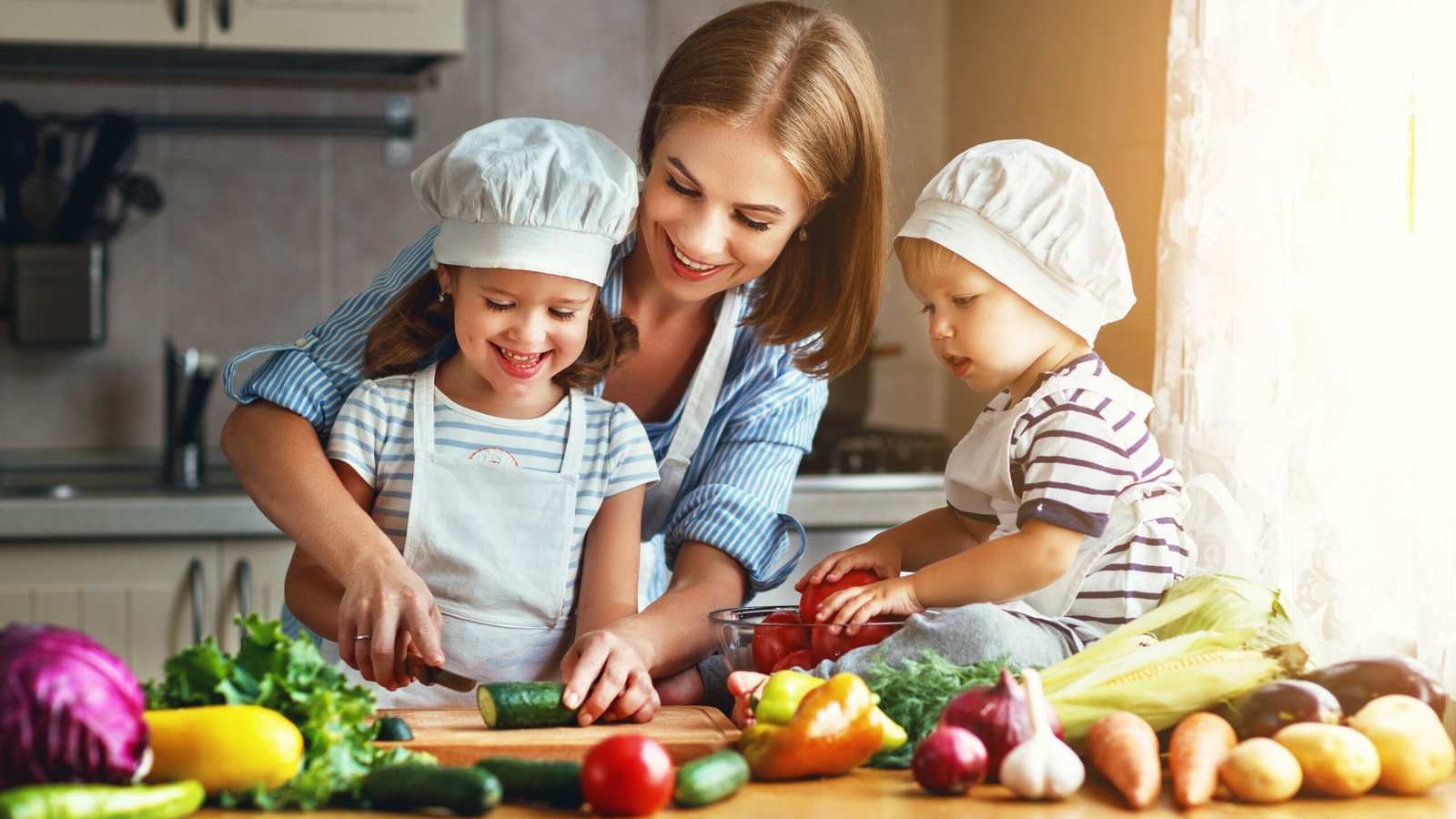 Healthy eating. Happy family mother and children  prepares   vegetable salad in kitchen